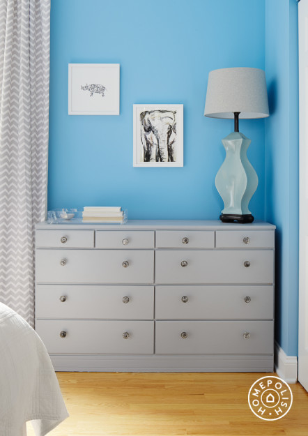 This is an example of a mid-sized modern guest bedroom in Chicago with blue walls and light hardwood floors.