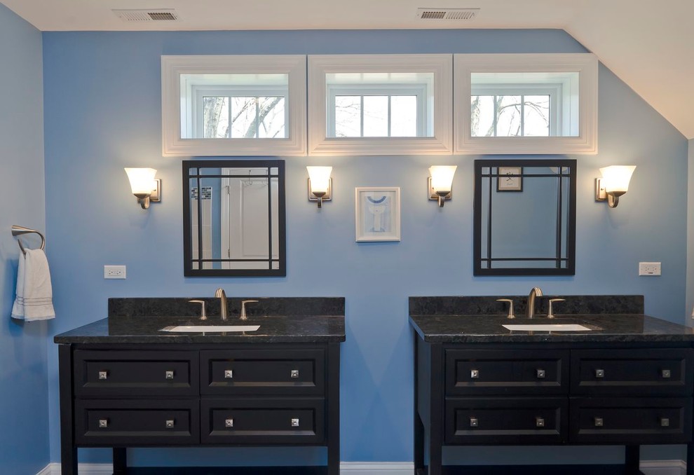This is an example of a transitional bathroom in Chicago with an undermount sink, furniture-like cabinets, black cabinets, granite benchtops, a drop-in tub, a corner shower and a one-piece toilet.