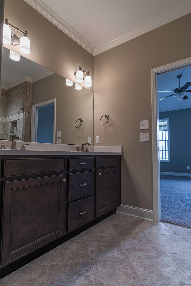 Bathroom - mid-sized transitional master beige tile travertine floor bathroom idea in DC Metro with shaker cabinets, dark wood cabinets, beige walls, an undermount sink and solid surface countertops