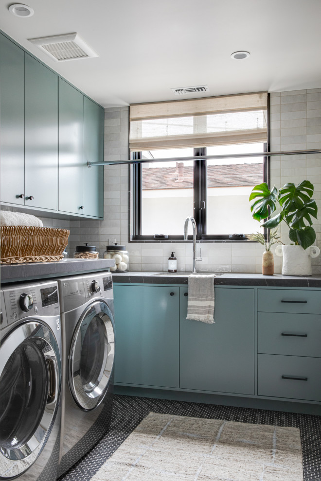 Inspiration for a mid-sized contemporary l-shaped dedicated laundry room in Orange County with an integrated sink, flat-panel cabinets, turquoise cabinets, quartz benchtops, white splashback, subway tile splashback, a side-by-side washer and dryer and black benchtop.