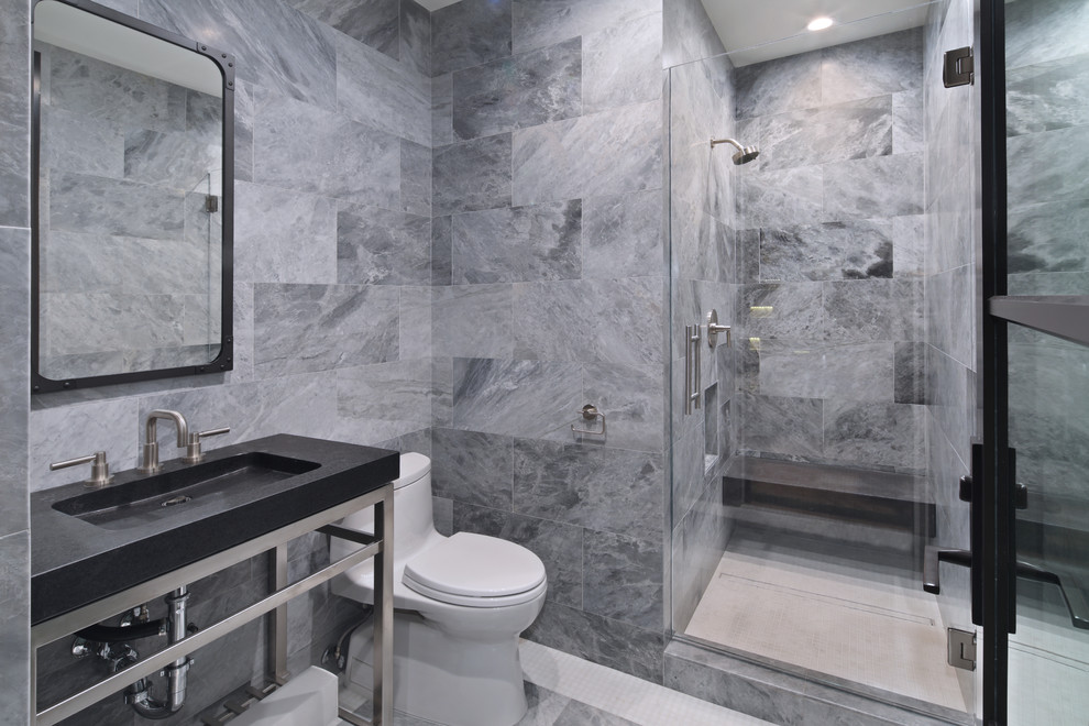 Design ideas for a contemporary 3/4 bathroom in Los Angeles with open cabinets, a corner shower, a one-piece toilet, gray tile, grey walls, an integrated sink, grey floor and a hinged shower door.