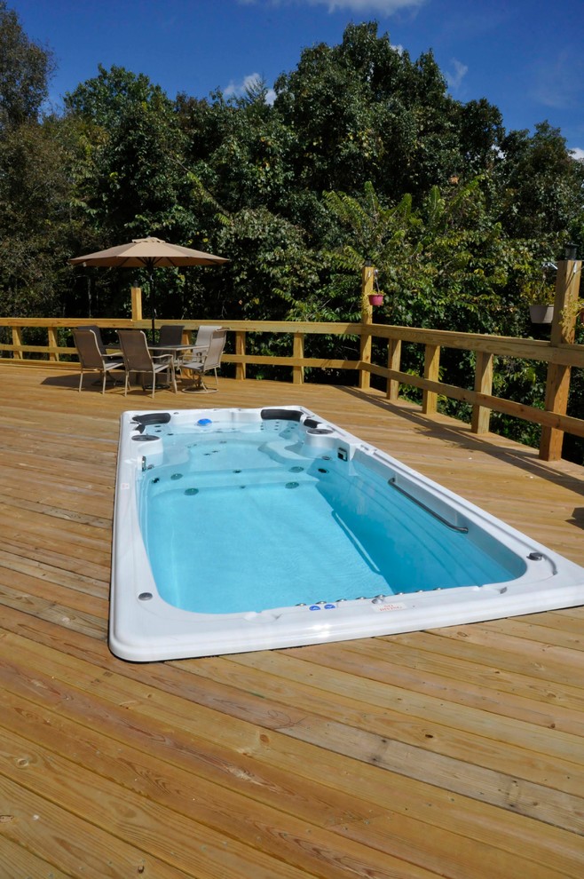 This is an example of a mid-sized country rooftop rectangular pool in Other with a hot tub and decking.