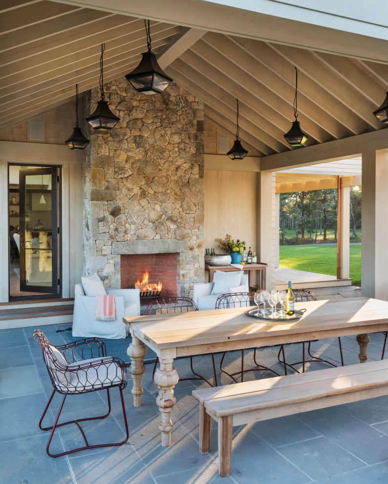 Inspiration for a country patio in Boston with with fireplace and a roof extension.