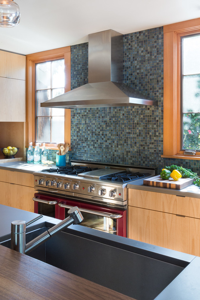 Inspiration for a mid-sized arts and crafts l-shaped open plan kitchen in San Francisco with a single-bowl sink, flat-panel cabinets, medium wood cabinets, concrete benchtops, blue splashback, ceramic splashback, stainless steel appliances, medium hardwood floors and with island.