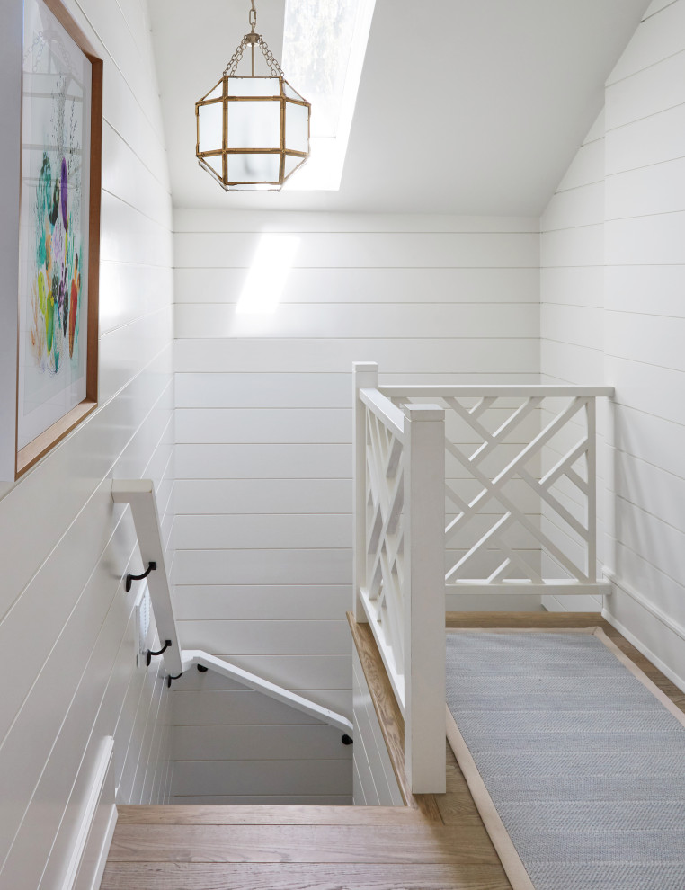 Foto på en liten svängd trappa, med heltäckningsmatta, sättsteg med heltäckningsmatta och räcke i trä