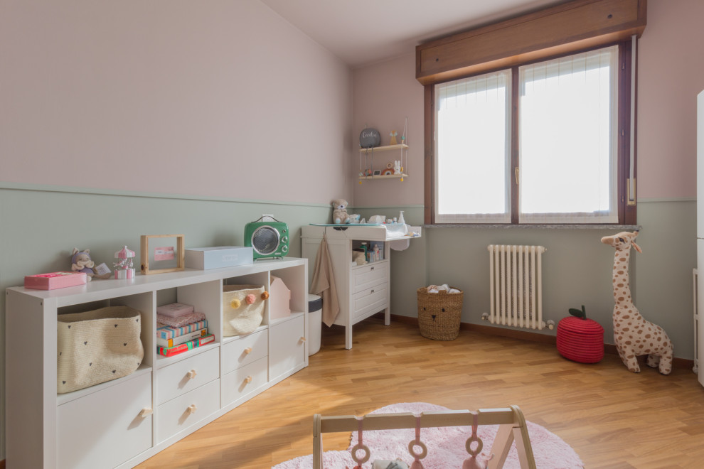 This is an example of a small modern kids' room for girls in Milan with light hardwood floors.