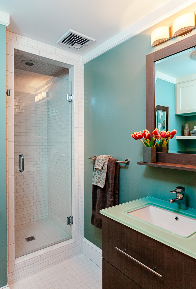 Design ideas for a transitional bathroom in Boston with flat-panel cabinets, dark wood cabinets, glass benchtops, an alcove shower, white tile, subway tile and blue walls.