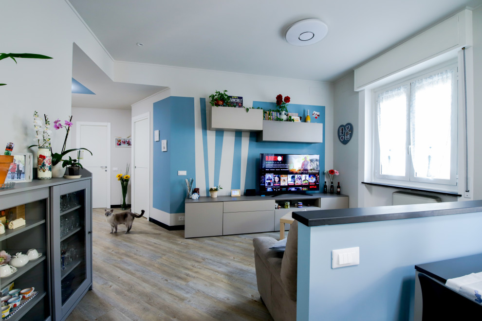 Свежая идея для дизайна: большая открытая гостиная комната в современном стиле с синими стенами, полом из ламината, телевизором, бежевым полом и любой отделкой стен - отличное фото интерьера