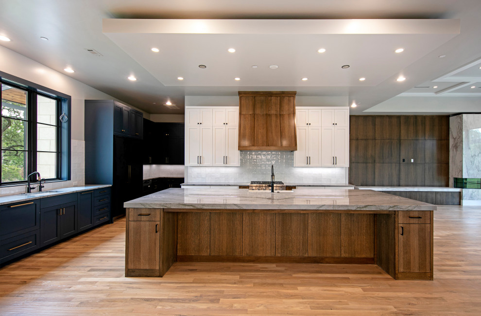 Eat-in kitchen - large transitional u-shaped eat-in kitchen idea in Dallas with flat-panel cabinets, dark wood cabinets, quartz countertops, white backsplash, stainless steel appliances, an island and gray countertops