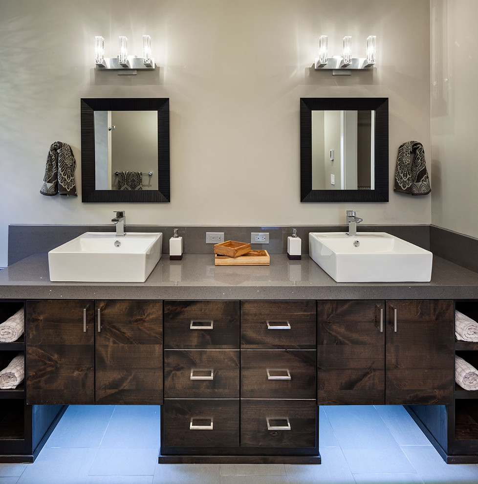 Photo of a large contemporary master bathroom in Portland with a vessel sink, flat-panel cabinets, dark wood cabinets, engineered quartz benchtops, an alcove shower, a two-piece toilet, gray tile, porcelain tile, grey walls, porcelain floors and grey benchtops.