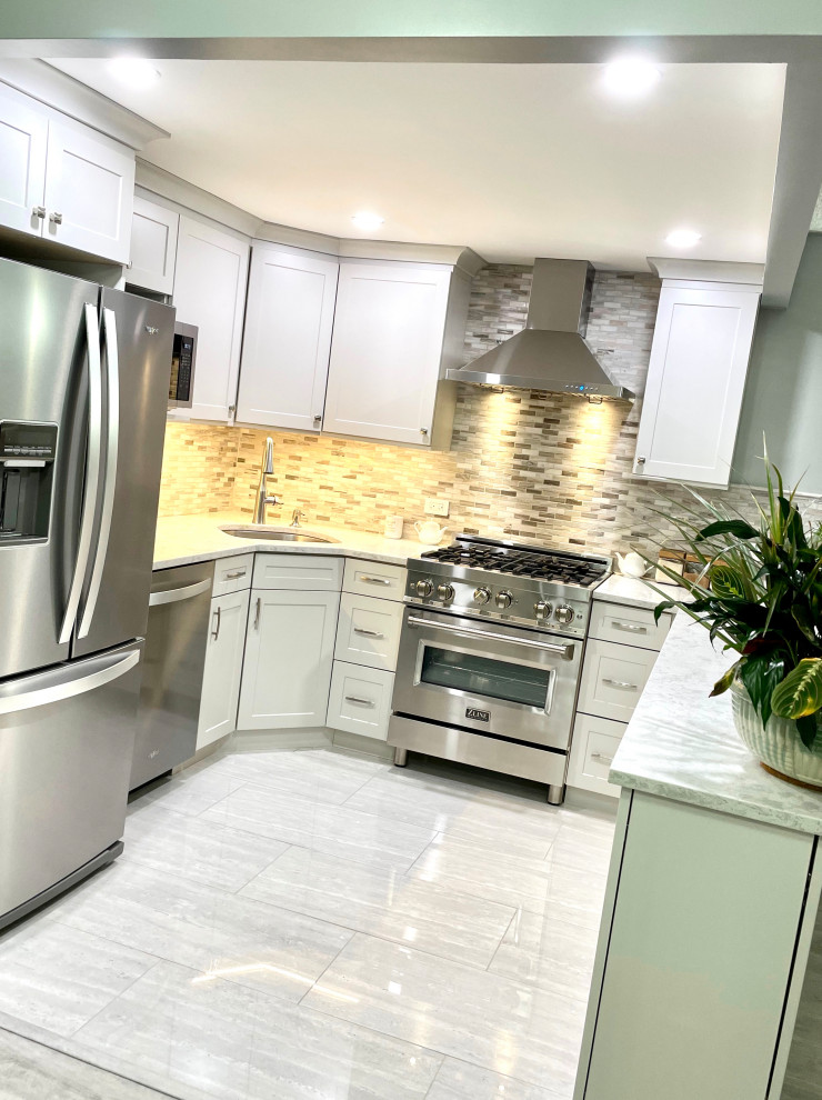 Inspiration for a mid-sized contemporary u-shaped kitchen in New York with a drop-in sink, shaker cabinets, white cabinets, quartz benchtops, yellow splashback, ceramic splashback, stainless steel appliances, laminate floors, with island, grey floor and white benchtop.