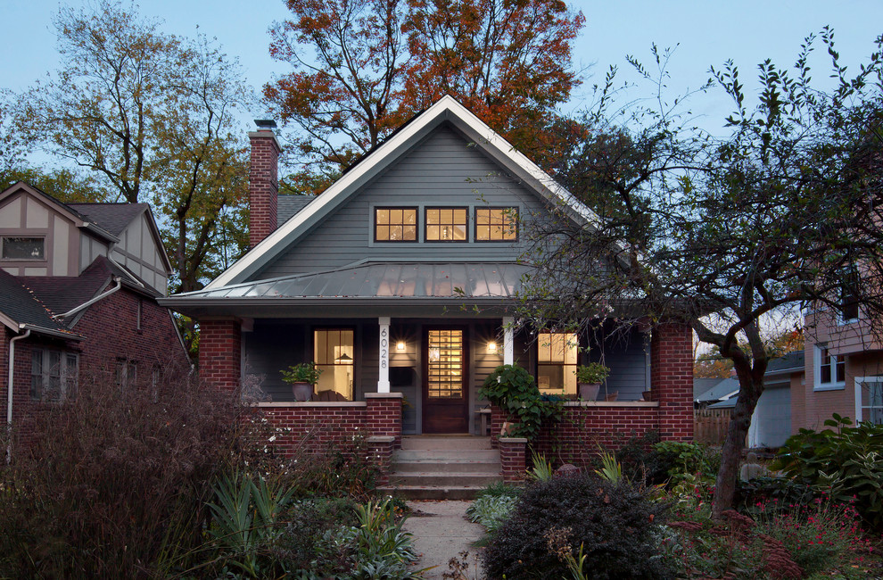 This is an example of a mid-sized transitional two-storey grey house exterior in Indianapolis with concrete fiberboard siding, a gable roof and a metal roof.