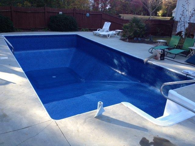 Backyard stamped concrete and rectangular pool photo