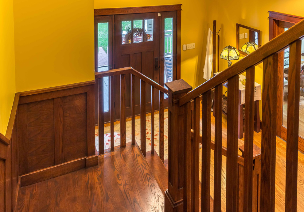 Photo of a mid-sized arts and crafts wood u-shaped staircase in Chicago with wood risers, wood railing and decorative wall panelling.