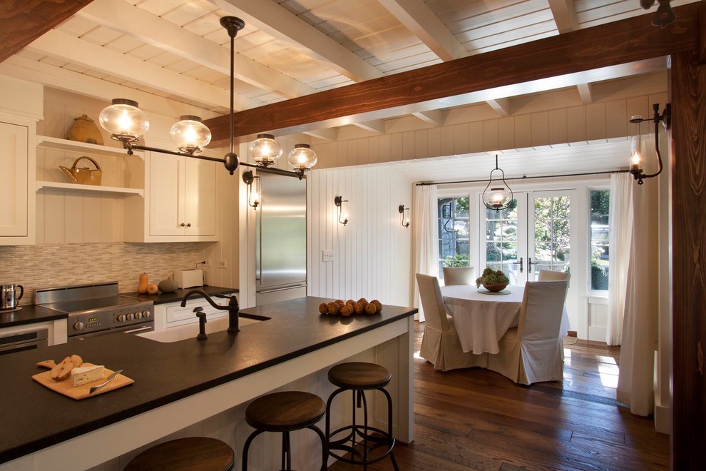 Photo of a country galley eat-in kitchen in Other with a farmhouse sink, shaker cabinets, white cabinets, granite benchtops and stainless steel appliances.