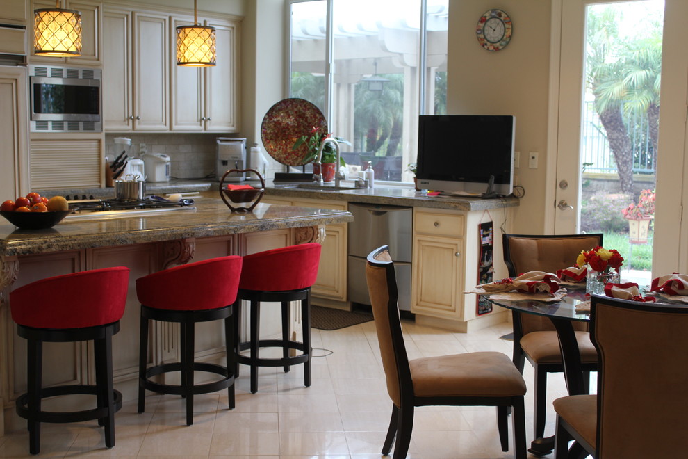 Enclosed kitchen - large transitional u-shaped ceramic tile and beige floor enclosed kitchen idea in Orange County with an undermount sink, recessed-panel cabinets, beige cabinets, granite countertops, beige backsplash, stone tile backsplash, stainless steel appliances, an island and beige countertops
