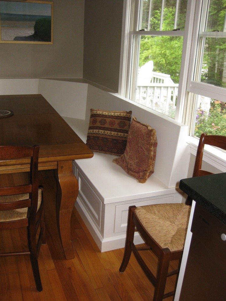 Inspiration for a transitional u-shaped medium tone wood floor eat-in kitchen remodel in Boston with an undermount sink, recessed-panel cabinets, white cabinets, gray backsplash, subway tile backsplash, stainless steel appliances, an island and black countertops