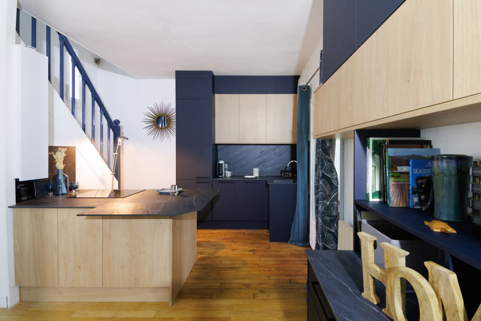 Пример оригинального дизайна: кухня в современном стиле с светлыми деревянными фасадами, серым фартуком и серой столешницей