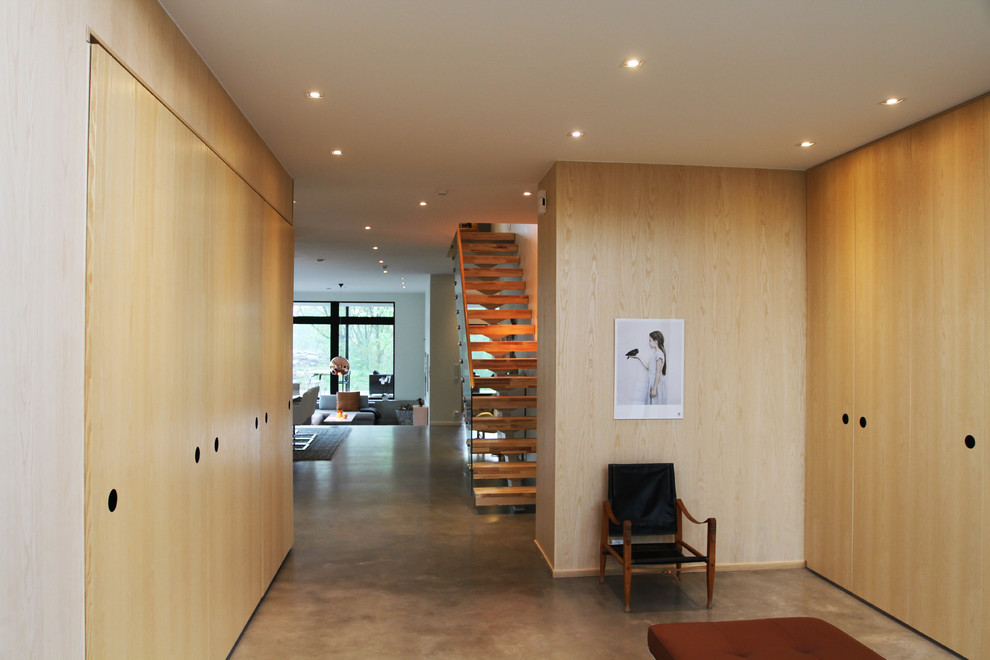 Photo of a large scandinavian hallway in Gothenburg with concrete floors and beige walls.