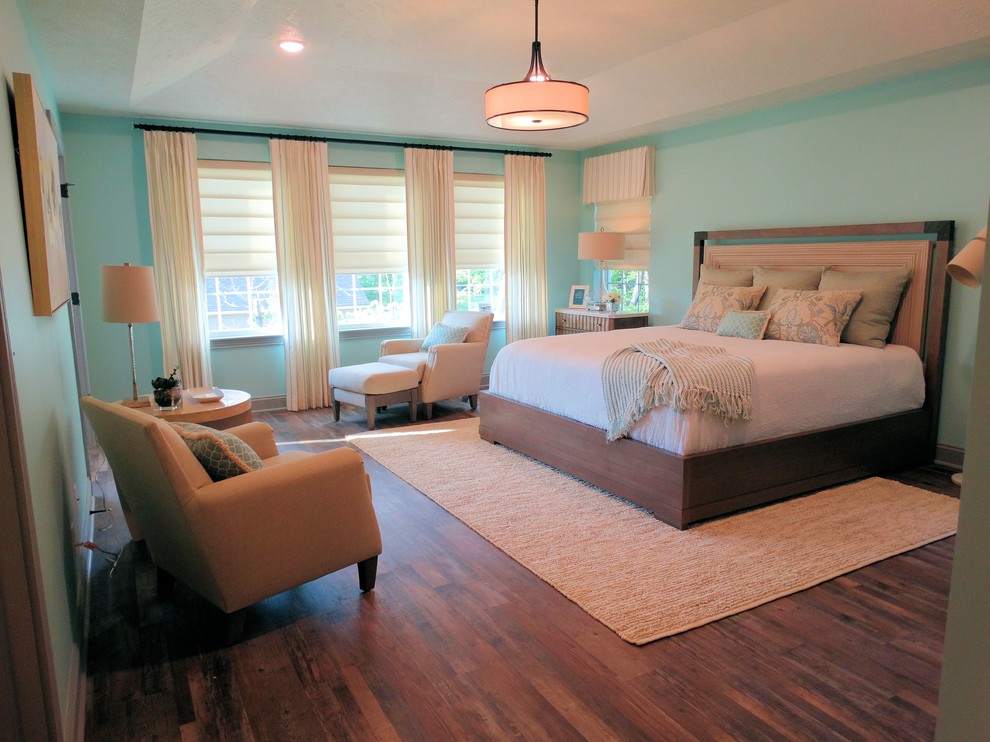 Photo of a large transitional master bedroom in Cleveland with blue walls, vinyl floors and brown floor.