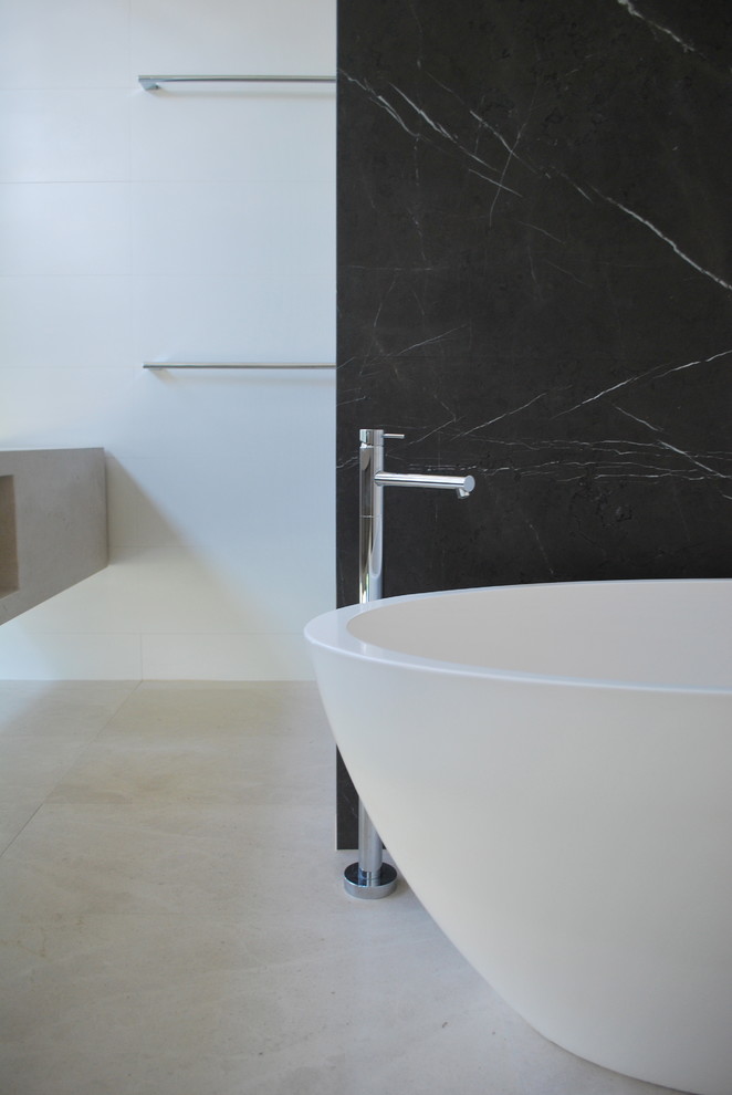 Contemporary kids bathroom in Perth with light wood cabinets, limestone benchtops, a freestanding tub, beige tile, stone tile, grey walls and limestone floors.