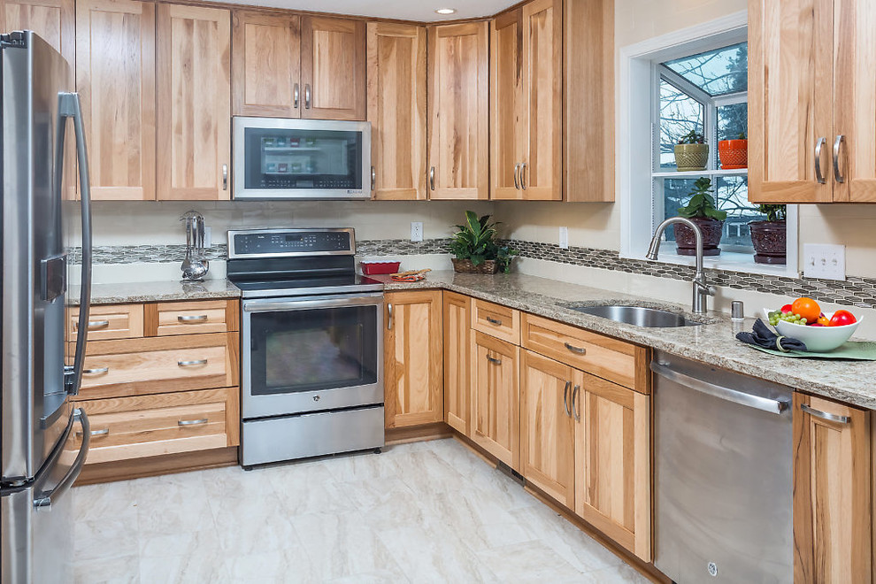Inspiration for a mid-sized transitional u-shaped enclosed kitchen remodel with an undermount sink, shaker cabinets, light wood cabinets, quartz countertops, white backsplash, subway tile backsplash, stainless steel appliances and no island