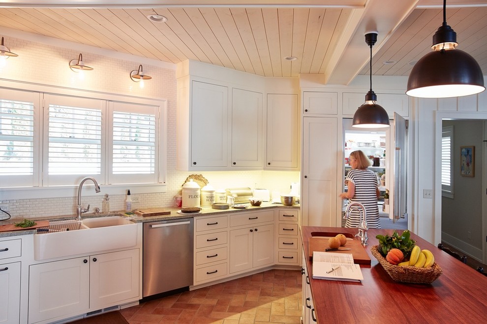 Large transitional l-shaped enclosed kitchen photo in Minneapolis with a farmhouse sink, recessed-panel cabinets, white cabinets, wood countertops, white backsplash, subway tile backsplash, stainless steel appliances and an island