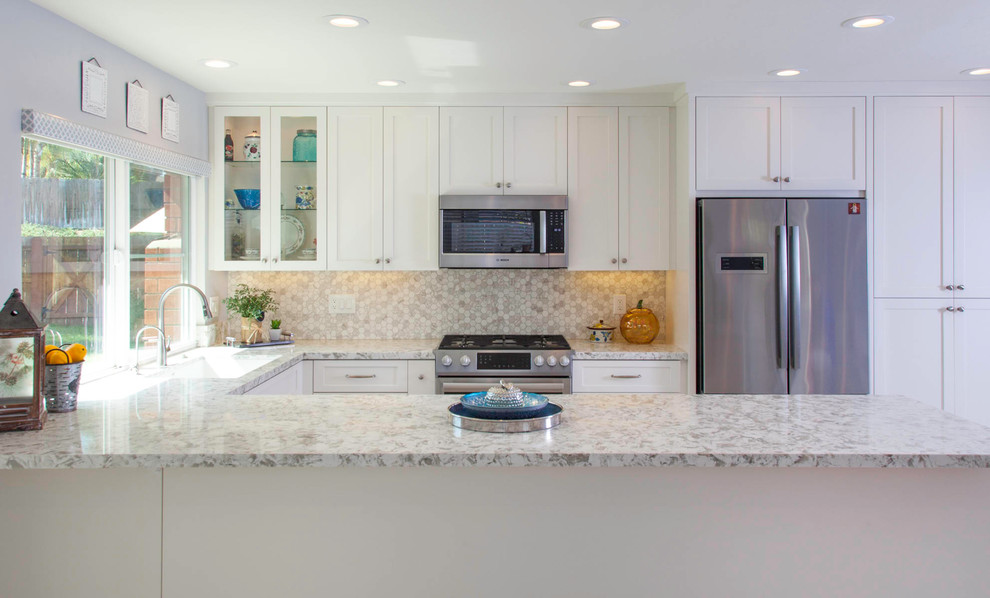 This is an example of a mid-sized contemporary u-shaped open plan kitchen in San Diego with an undermount sink, recessed-panel cabinets, white cabinets, quartz benchtops, white splashback, porcelain splashback, stainless steel appliances, porcelain floors, a peninsula, white floor and white benchtop.