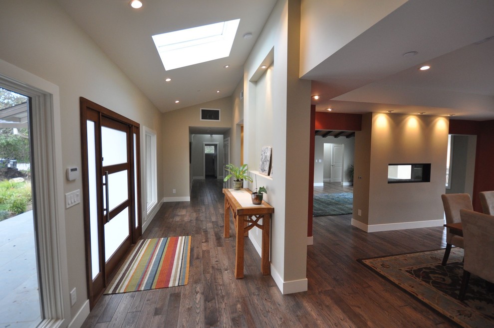 This is an example of a contemporary entryway in Los Angeles with dark hardwood floors and a single front door.