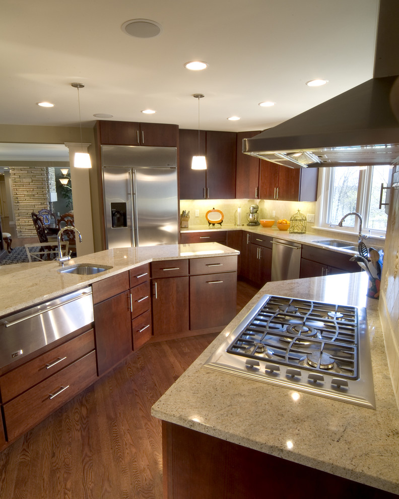 Trendy kitchen photo in Columbus with stainless steel appliances, a double-bowl sink, flat-panel cabinets and dark wood cabinets