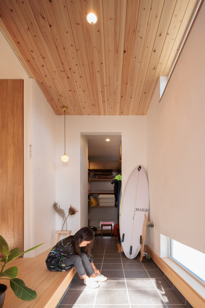 Ispirazione per un corridoio di medie dimensioni con pareti bianche, pavimento con piastrelle in ceramica e soffitto in legno