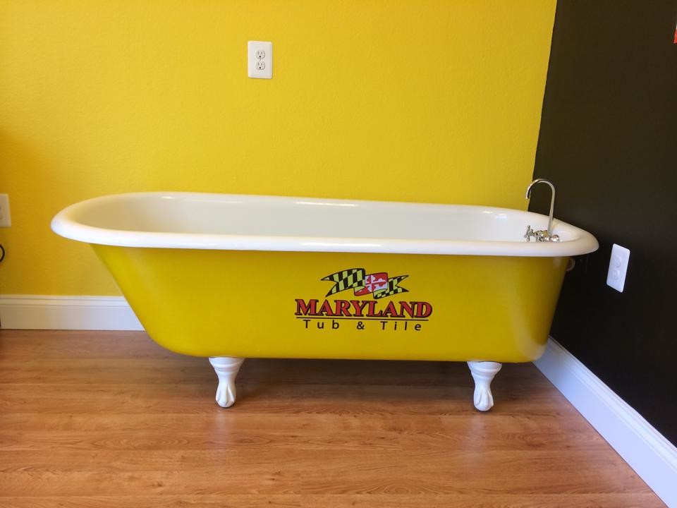 Cette image montre une petite salle de bain design avec une baignoire sur pieds, un carrelage jaune, un mur jaune et parquet clair.