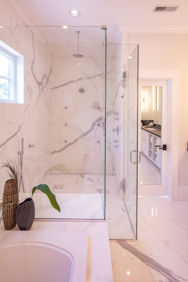 Large country master bathroom in Boston with shaker cabinets, white cabinets, a drop-in tub, a curbless shower, a one-piece toilet, white tile, stone tile, white walls, porcelain floors, an undermount sink, granite benchtops, white floor, a hinged shower door and black benchtops.