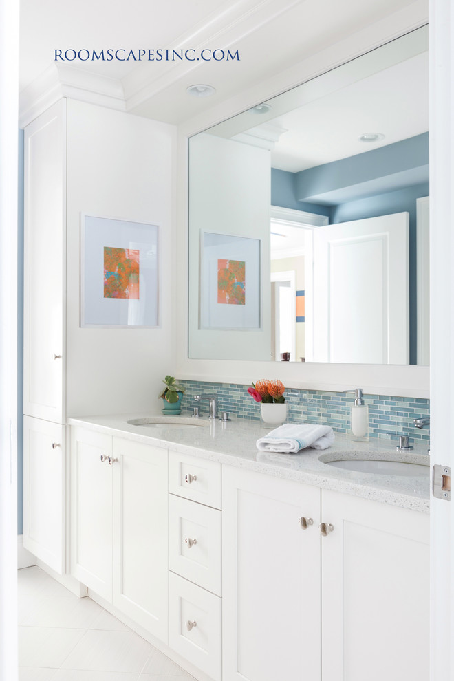 This is an example of a mid-sized eclectic bathroom in Boston with an undermount sink, raised-panel cabinets, white cabinets, marble benchtops, a shower/bathtub combo, blue tile, mosaic tile, blue walls and ceramic floors.