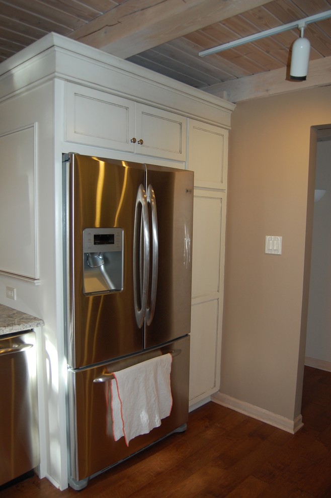 Mid-sized transitional u-shaped medium tone wood floor open concept kitchen photo in Chicago with an undermount sink, flat-panel cabinets, dark wood cabinets, granite countertops, beige backsplash, stone tile backsplash, stainless steel appliances and a peninsula