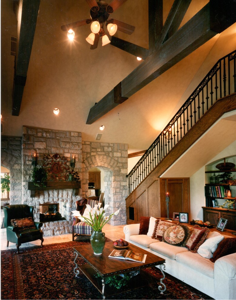 This is an example of a large family room in Oklahoma City with beige walls, travertine floors and a two-sided fireplace.