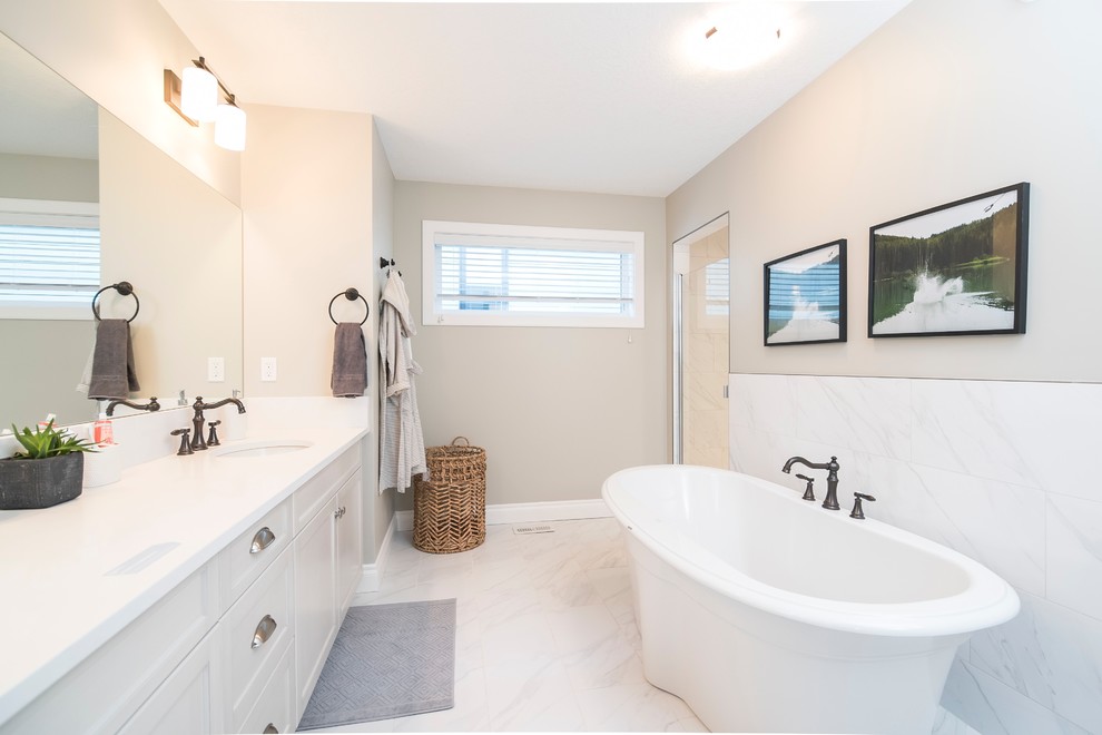 Design ideas for a large modern master bathroom in Dallas with flat-panel cabinets, white cabinets, a japanese tub, a shower/bathtub combo, a one-piece toilet, white tile, ceramic tile, white walls, ceramic floors, a wall-mount sink, granite benchtops, grey floor and white benchtops.