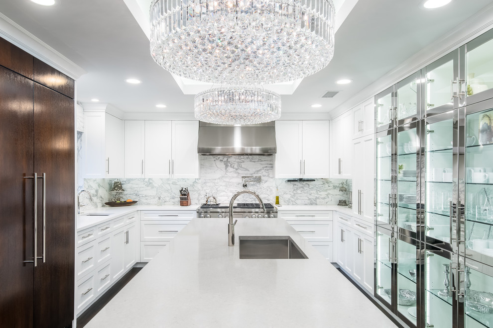 Photo of a large contemporary u-shaped eat-in kitchen in Dallas with an undermount sink, white cabinets, stainless steel appliances, with island, white benchtop, recessed-panel cabinets, quartz benchtops, white splashback, marble splashback, dark hardwood floors, brown floor and recessed.