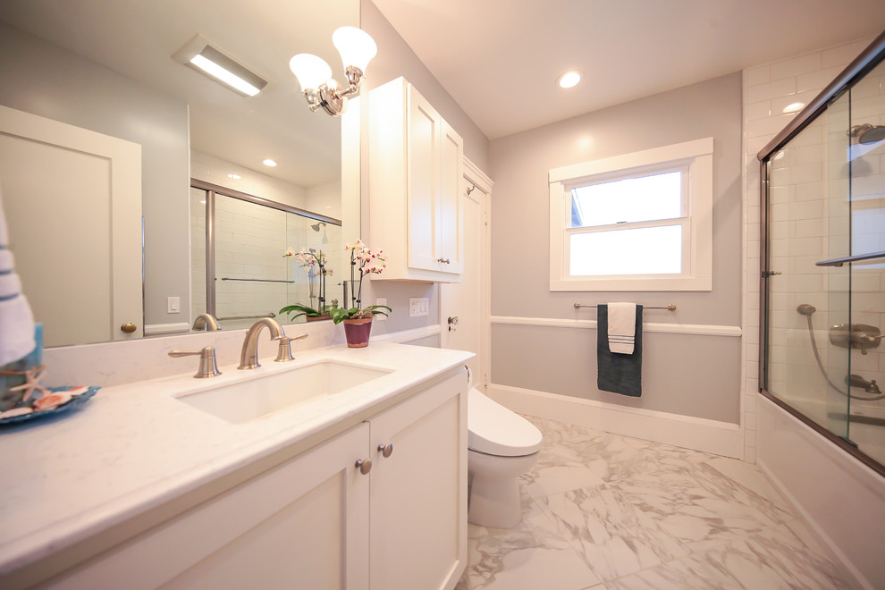 Mid-sized traditional master bathroom in San Francisco with recessed-panel cabinets, white cabinets, a drop-in tub, a shower/bathtub combo, a bidet, white tile, white walls, linoleum floors and a pedestal sink.