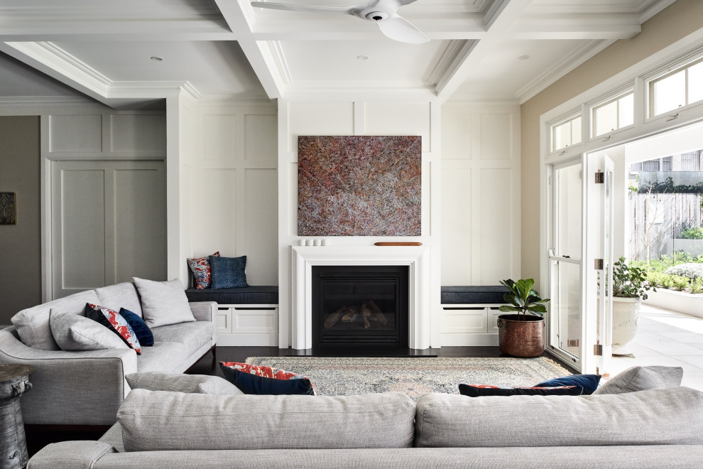 シドニーにある広いトランジショナルスタイルのおしゃれなLDK (濃色無垢フローリング、標準型暖炉、木材の暖炉まわり、テレビなし、茶色い床、格子天井) の写真