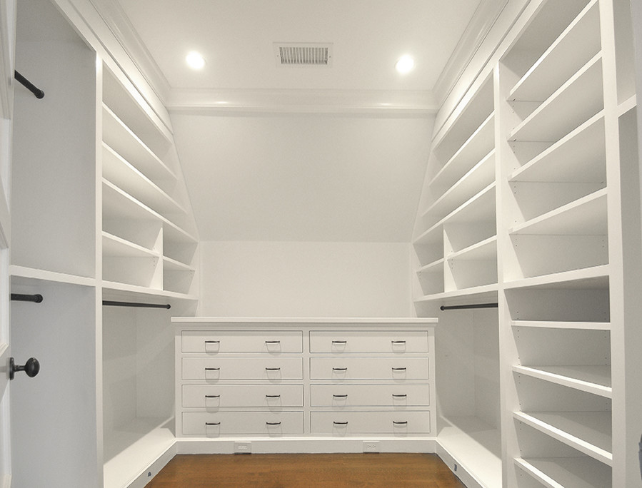 Design ideas for a large transitional gender-neutral walk-in wardrobe in New York with flat-panel cabinets, white cabinets and medium hardwood floors.