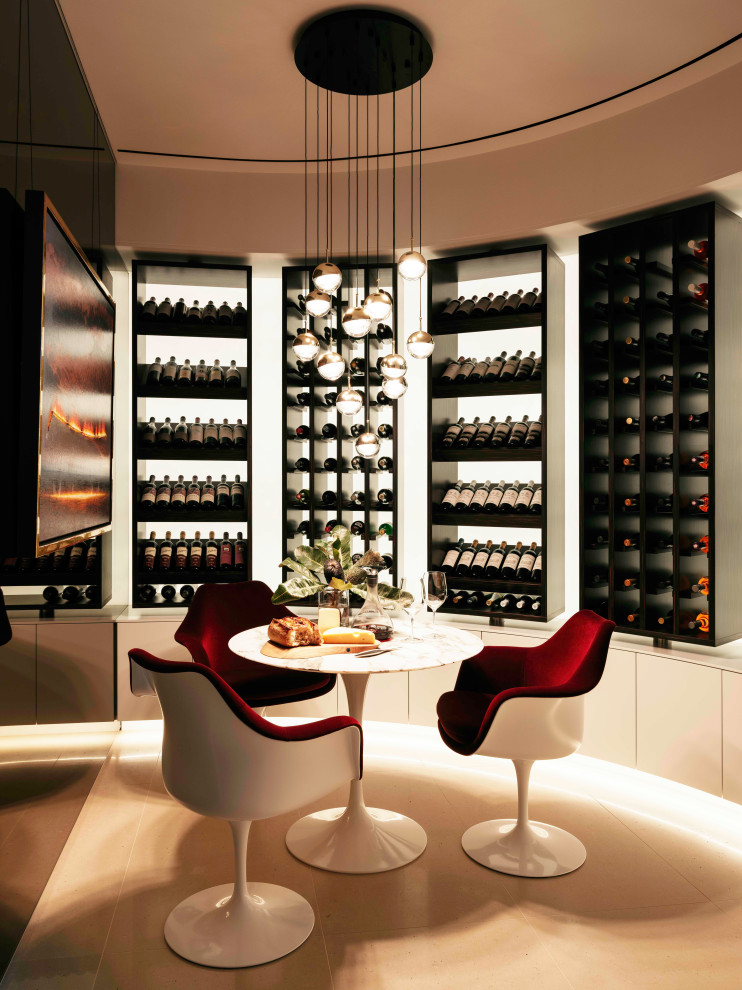This is an example of a mid-sized modern wine cellar in Sydney with ceramic floors, display racks and beige floor.