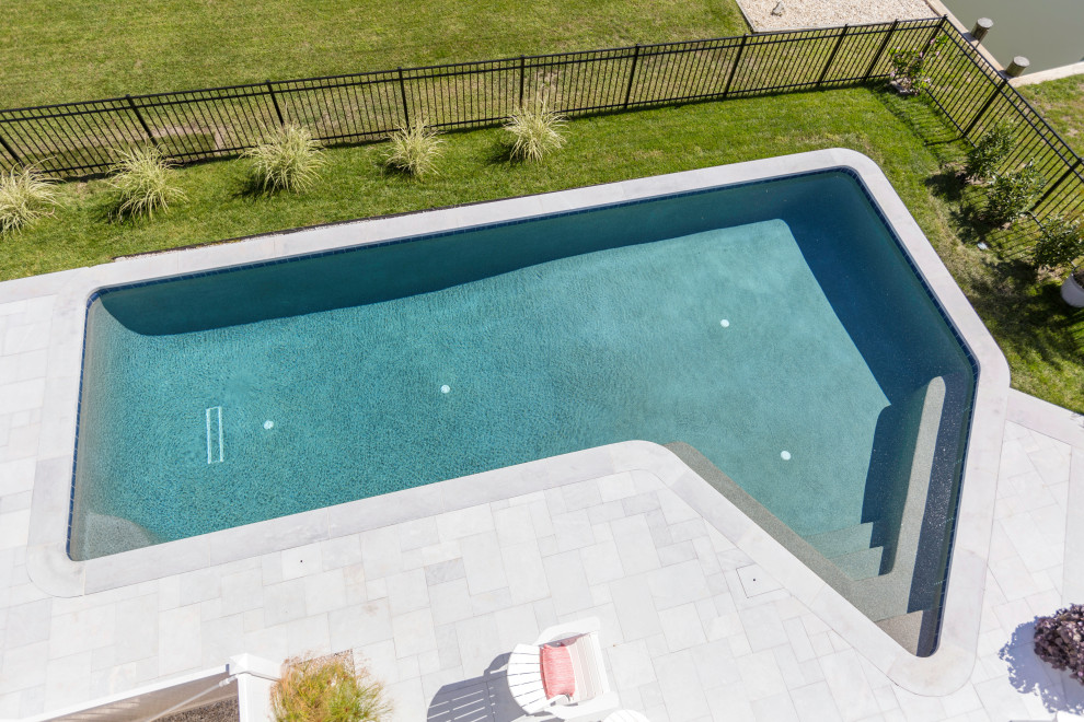 Ispirazione per una piscina costiera personalizzata di medie dimensioni e nel cortile laterale con pavimentazioni in pietra naturale