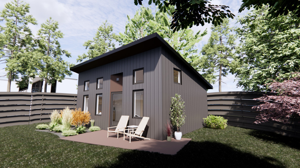 Foto på ett litet funkis svart hus, med allt i ett plan, fiberplattor i betong, pulpettak och tak i shingel