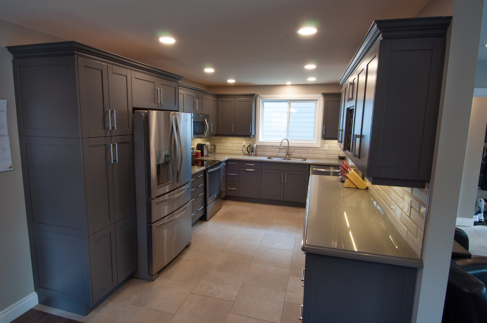 Inspiration for a mid-sized transitional u-shaped ceramic tile and beige floor enclosed kitchen remodel in Toronto with a double-bowl sink, shaker cabinets, dark wood cabinets, quartzite countertops, beige backsplash, subway tile backsplash, stainless steel appliances and no island