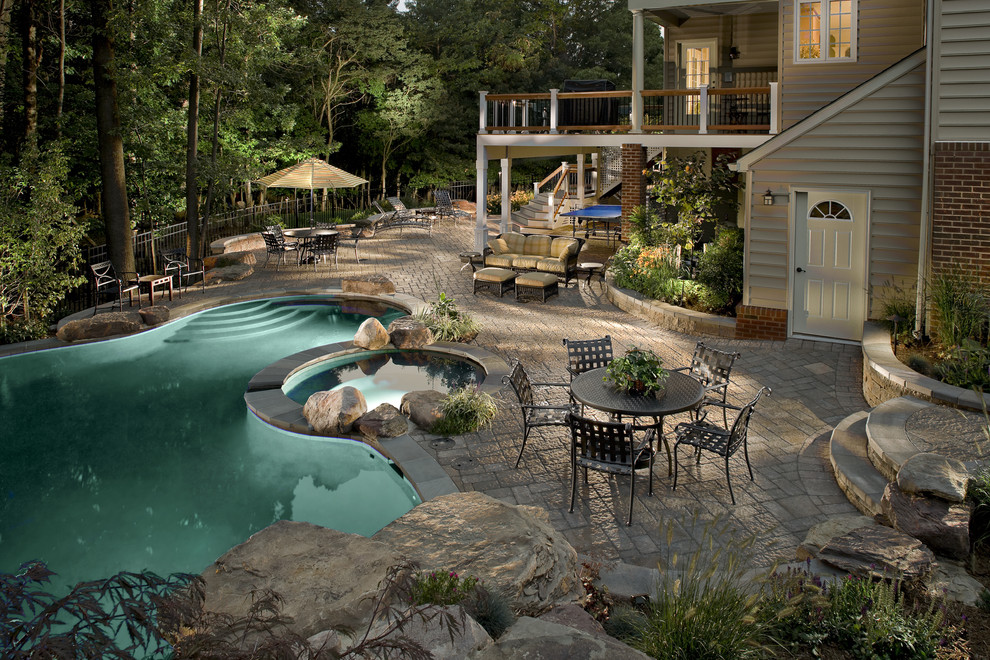 Large contemporary backyard custom-shaped natural pool in DC Metro with concrete pavers and a hot tub.