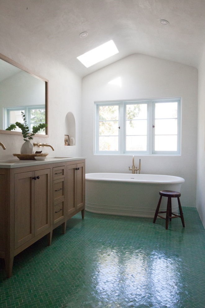 Mid-sized mediterranean master bathroom in Los Angeles with recessed-panel cabinets, medium wood cabinets, engineered quartz benchtops, white benchtops, a freestanding tub, white walls, ceramic floors, an undermount sink and green floor.