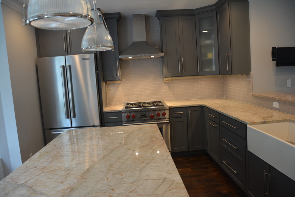 Eat-in kitchen - mid-sized transitional l-shaped dark wood floor eat-in kitchen idea in Boston with a farmhouse sink, raised-panel cabinets, gray cabinets, quartzite countertops, gray backsplash, subway tile backsplash, stainless steel appliances and an island