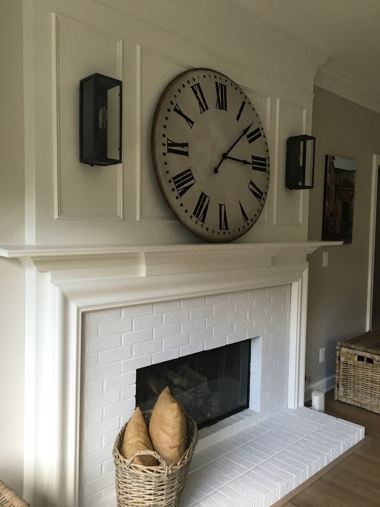 Example of a large cottage open concept medium tone wood floor living room design in DC Metro with gray walls, a standard fireplace, a brick fireplace and no tv