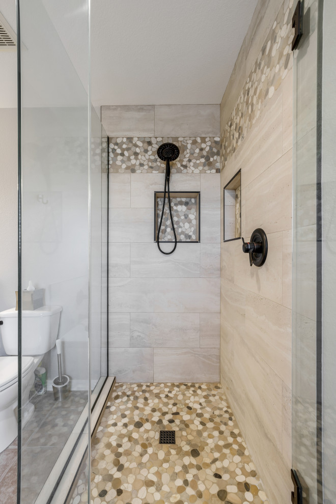 Cette image montre une grande douche en alcôve principale design avec WC séparés, un carrelage beige, des carreaux de porcelaine, un mur marron, un sol en galet, une vasque, un sol multicolore, une cabine de douche à porte battante et une niche.